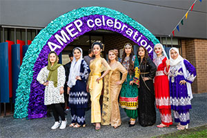 Group photoshoot of students dressed in their colorful national costumes in celebration of AMEP 75th year.