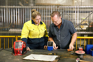 A apprentice in the engineering industry receiving instructions from her instructor.