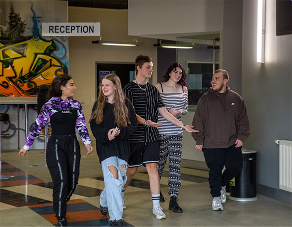 A group of young adult students walking within the campus.